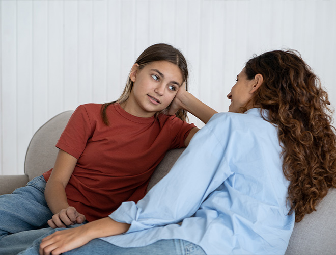 mother talking to her daughter abut anxiety on a couch