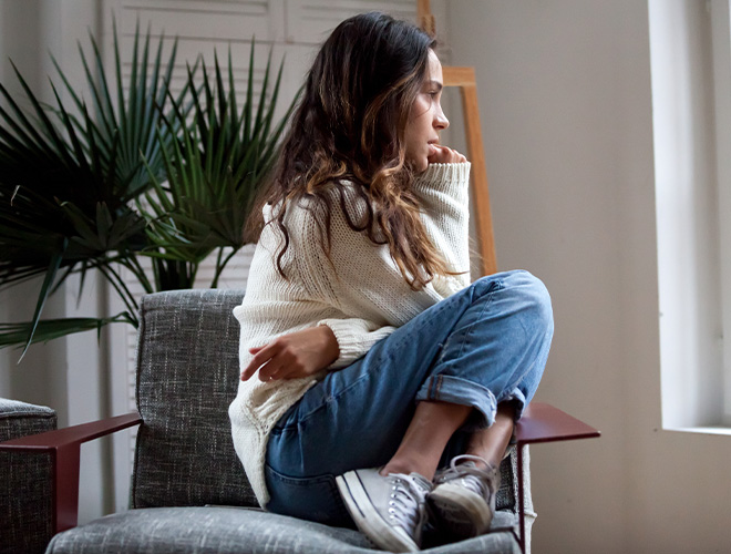 Teenage girl sitting in a chair struggling with ADHD and anxiety