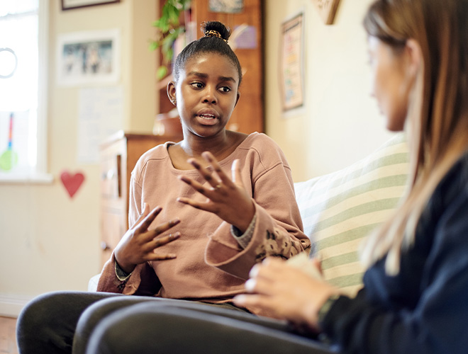 Teenage girl speaking to a female clinician practicing Distress Tolerance Skills